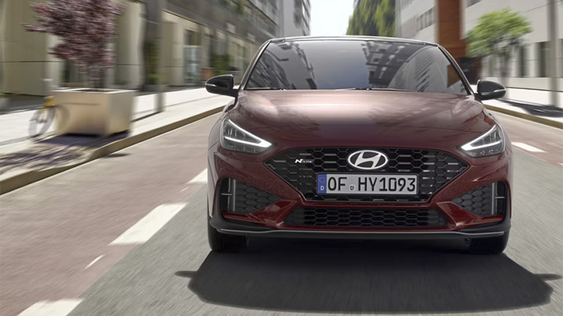 Hyundai i30 Fastback N LINE - přední pohled na tmavěčervený vůz, který jede ulicemi města